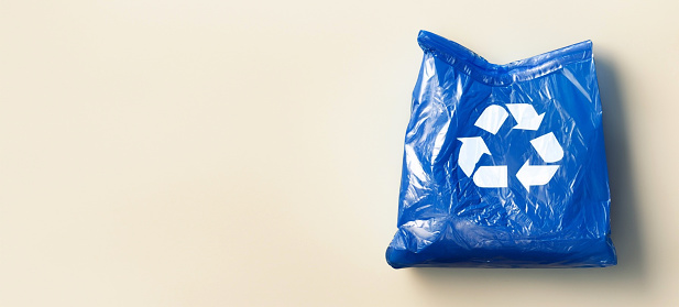Recycle sign on blue plastic bag