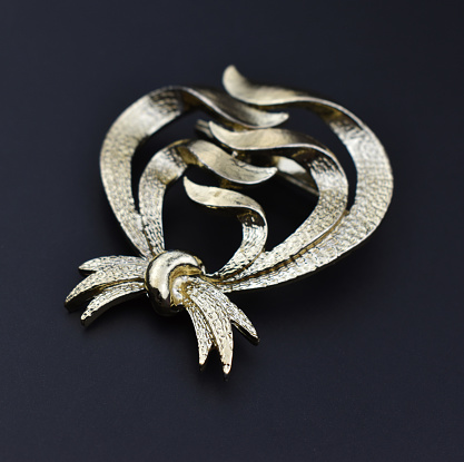 A stunning vintage brooch, elegantly displayed on a sleek black background, serves as the perfect accent piece for retro-loving women. This captivating promotional photo embodies timeless beauty and can be found in our online jewelry store.