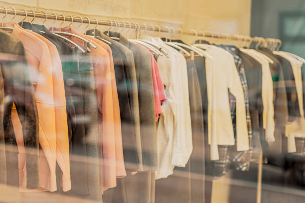 istock Womens clothes hanging on rail. Blurred View through shop window 1717371978