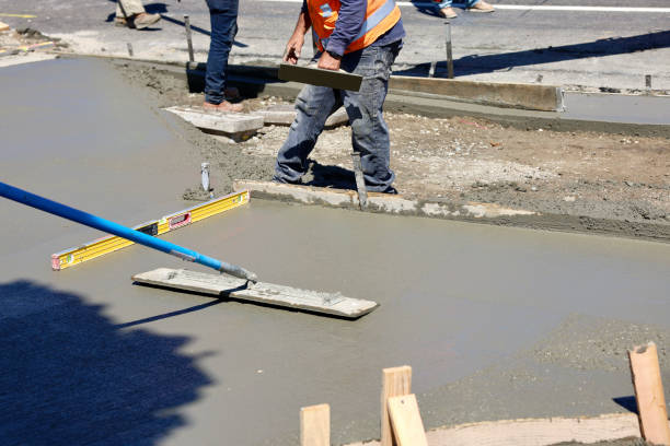 istock Road construction crew pouring concrete for the new sidewalk 1717401801
