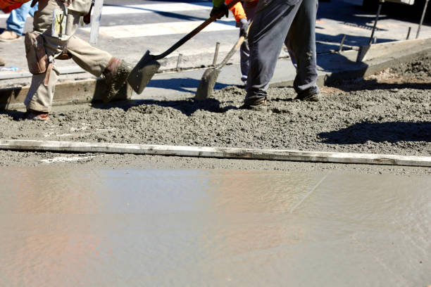 istock Road construction crew pouring concrete for the new sidewalk 1717402341