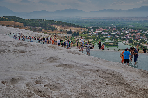 Pamukkale, Denizli Turkey, Travertines of Pamukkale, a Natural thermal pools surrounded by white limestone, accessed by a walk over rough rocks.