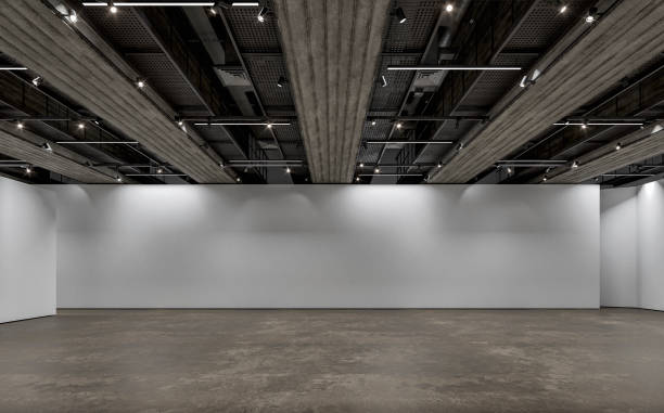 istock Side view of an empty white large, long gallery/showroom interior with white partition empty walls for events or artwork exposure, and a ceiling industrial construction with reflectors (lights) 1717434338