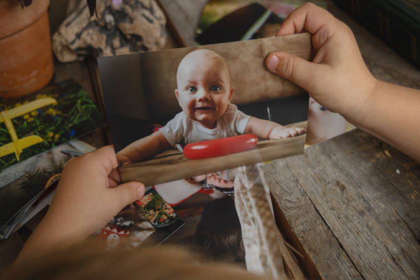 istock Photo printing concept. Kid looking at printed photos. 1717446665