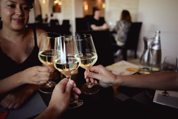 istock close up of toasting with white wine in restaurant. 1717458090