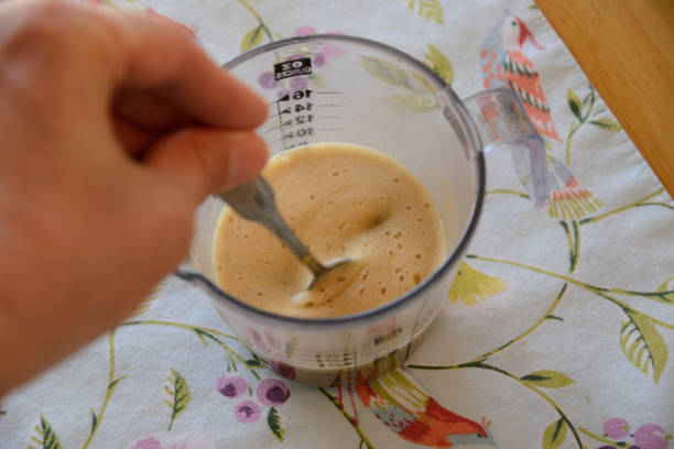 istock Proofing and stirring commercial yeast wih spoon 1717464485