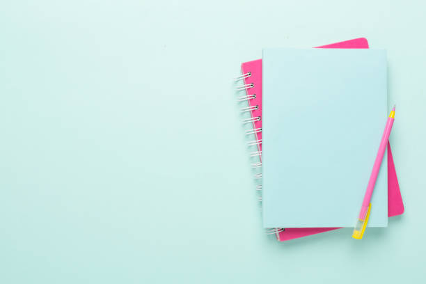 istock Notebooks with pen on color background, top view 1717465623