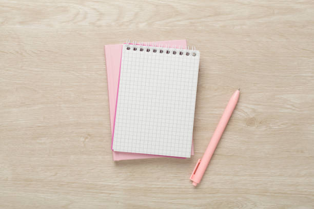 istock Notebooks with pen on wooden background, top view 1717465630
