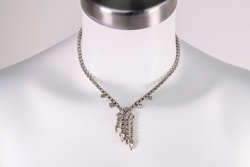 A stunning vintage-inspired necklace for women elegantly showcased on a white mannequin, exuding timeless charm and allure. This promotional photo captures the essence of a unique jewelry piece, perfect for an online jewelry store.