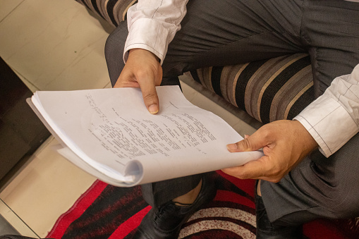 Male actor reading scripts before shooting