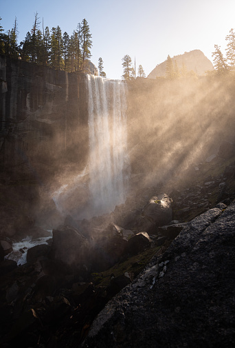 Bridalveil Fall flowing in magical Yosemite National Park, California, while the sun's rays cut through the water