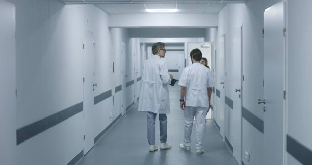 istock Doctors walk along the clinic corridor, discuss work, use tablet 1717621355