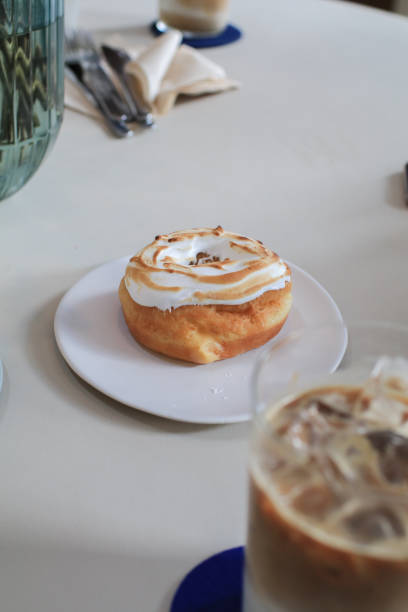 istock Lemon meringue donut on white plate.  Sweet summer dessert. Minimal concept. Doughnuts and bakery. 1717687910