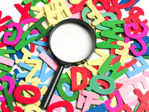 istock Magnifying glass with alphabetical wood letters. Learning English language concept. 1717696504