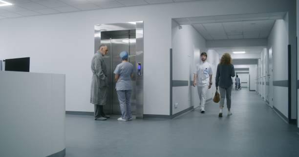 istock Nurse with old patient wait for elevator in medical center hallway 1717719448