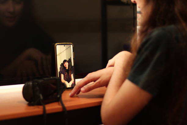 istock Photographer Giving Posing Instructions to a Model in a Virtual Shoot via Video Call 1717744111