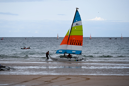 Fréhel, France, August 25, 2023 - Hobie 16 Catamarans of a sailing school on the beach of Sables-d'Or-les-Pins, Côtes d'Armor, Brittany.