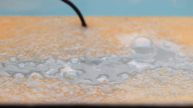 water and bubbles with rust on the surface from an electrolysis