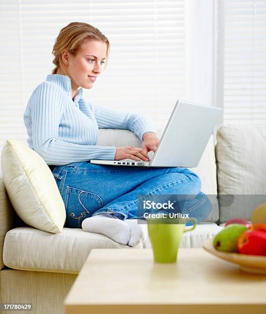 Pretty Blond Relaxing On Sofa And Using Laptop Stock Photo - Download Image Now - Adult, Cheerful, Color Image