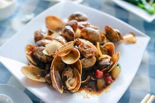 A plate of clams cooked in black bean chili garlic sauce at a Cantonese seafood restaurant along Cheung Chau Pier in Hong Kong