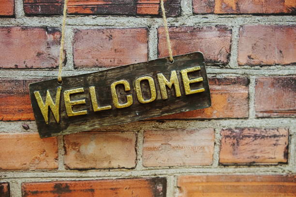 istock Welcome sign hanging on brick wall background 1717808148