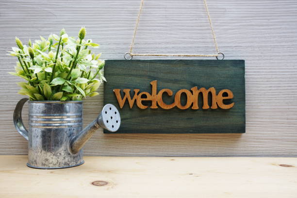 istock Welcome Sign with alarm clock on wooden background 1717809985