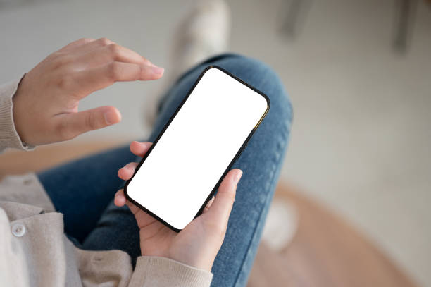 istock Top view image of a white-screen smartphone mockup is in a woman's hands. 1717826898
