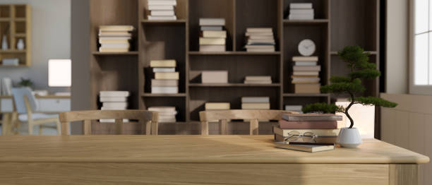 istock Copy space on a wooden tabletop with a blurred large bookshelf in the background. 1717829021