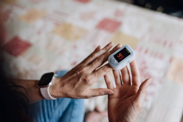 istock Woman using oximeter on her finger at home 1717832631