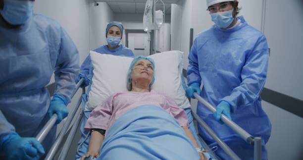 istock Doctors push gurney with elderly woman and talk 1717836174