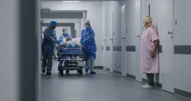 istock Paramedics push gurney with man to surgery room 1717840426
