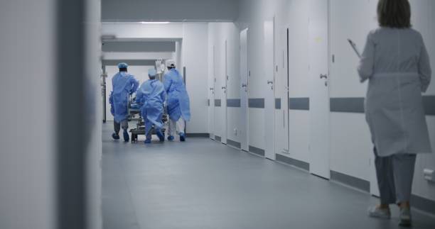 istock Paramedics push gurney with man to surgery room 1717840444