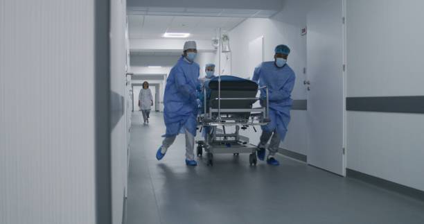istock Doctors push stretcher with man to surgery room 1717840694