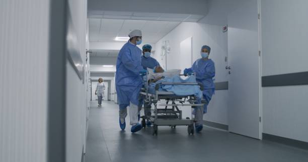 istock Doctors push stretcher with man to surgery room 1717840786