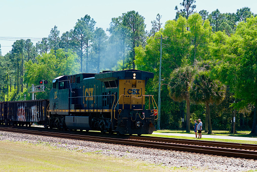 Folkston, Georgia, USA - April 5, 2021: A CSX freight locomotive travels through the “Folkston Funnel” in southeast Georgia near the Florida state line.