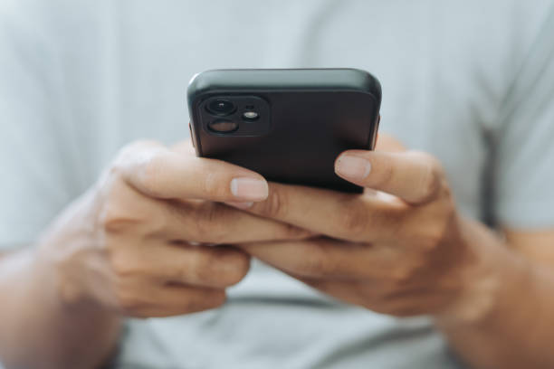 istock Hands of Asian man holding checking touching scrolling smartphone from bed room 1717866756