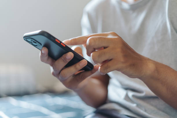 istock Hands of Asian man holding checking touching scrolling smartphone from bed room 1717868823