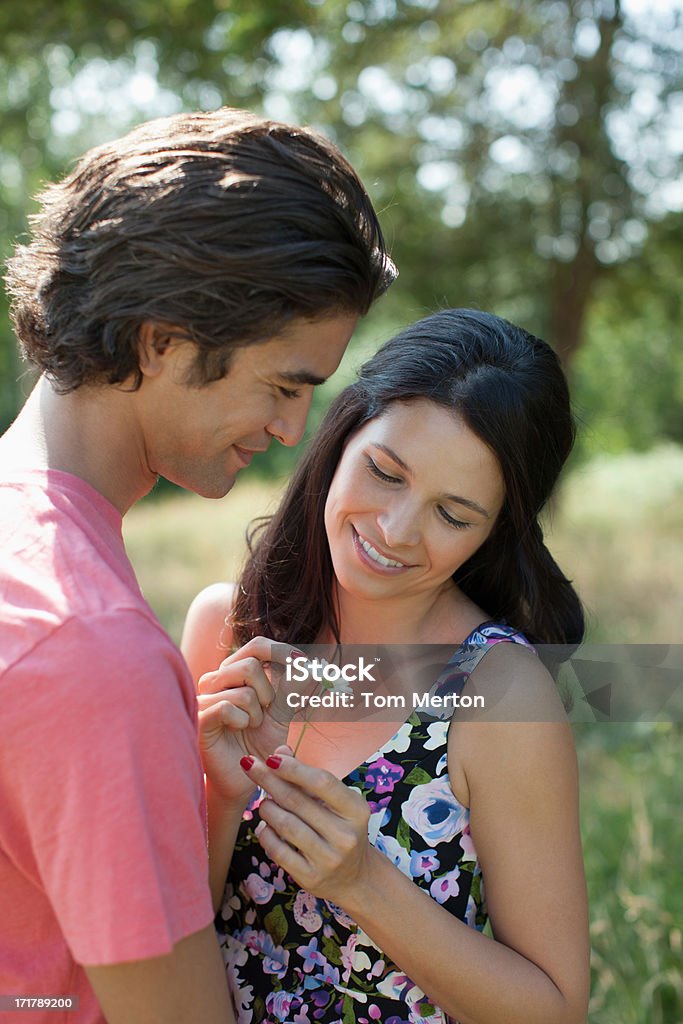 Sonriente pareja puntear pétalos de Margarita - Foto de stock de Grupo multiétnico libre de derechos