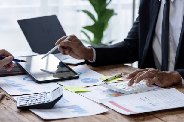 istock Business People Meeting using chart graph calculator, laptop computer,stock market chart paper for analysis Plans to improve quality next month, Conference Discussion Corporate Concept. 1717954889