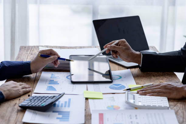 istock Business People Meeting using chart graph calculator, laptop computer,stock market chart paper for analysis Plans to improve quality next month, Conference Discussion Corporate Concept. 1717954897