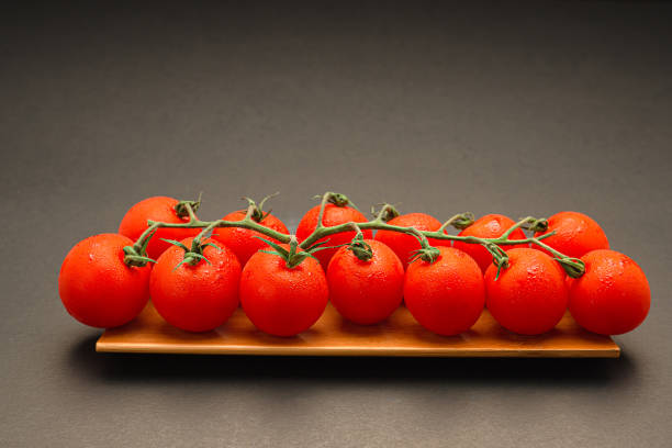 テーブルの上の木製トレイに赤い熟した新鮮なチェリートマト
