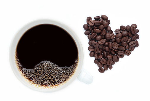 Top view white cup of coffee on white background. Cup of coffee isolated on white background with coffee beans in heart shape.