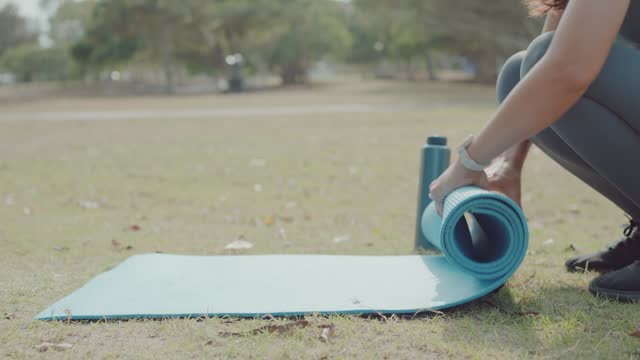 Young Asian woman practicing online yoga in the park, self care, active healthy lifestyle