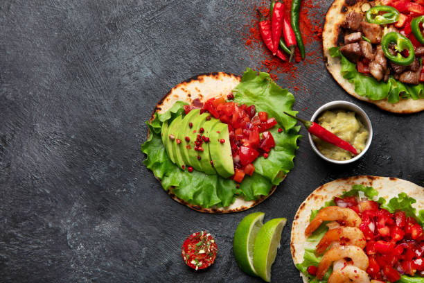 istock Tacos with salsa, vegetables and avocado on black background 1718086953