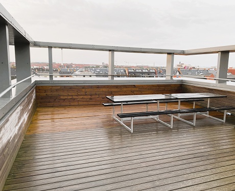 Fashionable rooftop deck with a stunning view of the city of Copenhagen, Denmark just after rainfall.