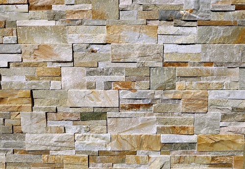 Muro de piedra hecho de rocas naturales multicolores de diferentes tamaños y formas. photo