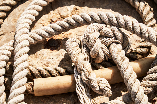 Still life of a thick rope improperly folded on the ground at the harbor