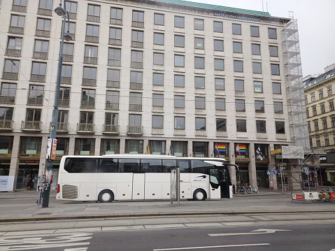 Image of the front of a blue city trolleybus on a city street stopped in front of a pedestrian crossing.
