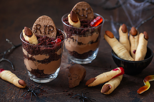 Sweet and funny  desserts for Halloween party. Dirt graveyard chocolate cups, chocolate scull and Witch Finger cookies
