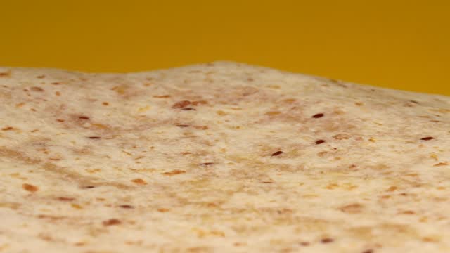 flatbread, rotation in circle on a yellow background. Mexican tortilla, Turning.